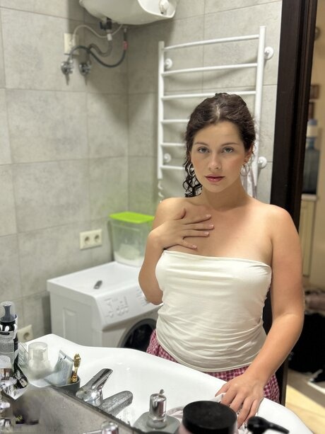 Solo model Ashley Shining Star uncovers her natural tits in a bathroom