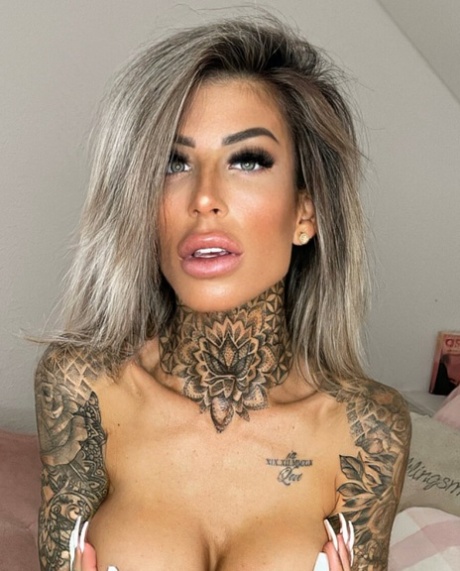 Amateur babe with tattoos covers her great juggs and poses in a solo