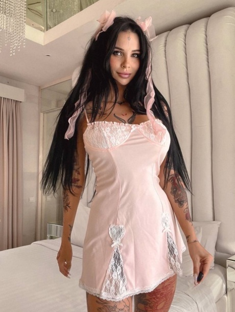 Tattooed brunette shows off her big boobs & her great ass on her bed